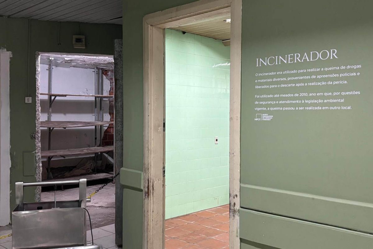 Espaço expositivo do Museu Paranaense de Ciências Forenses dedicado ao antigo incinerador, com texto curatorial na parede